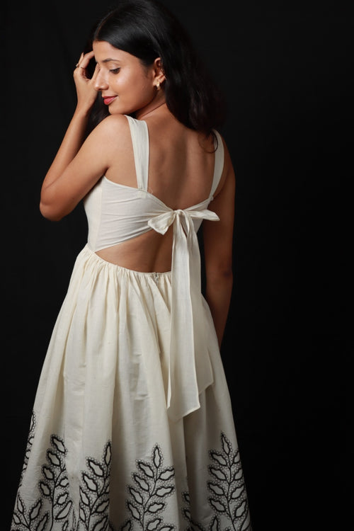 A light colored with mid length fitted bodice and flared skirt with distinctive embroidered
