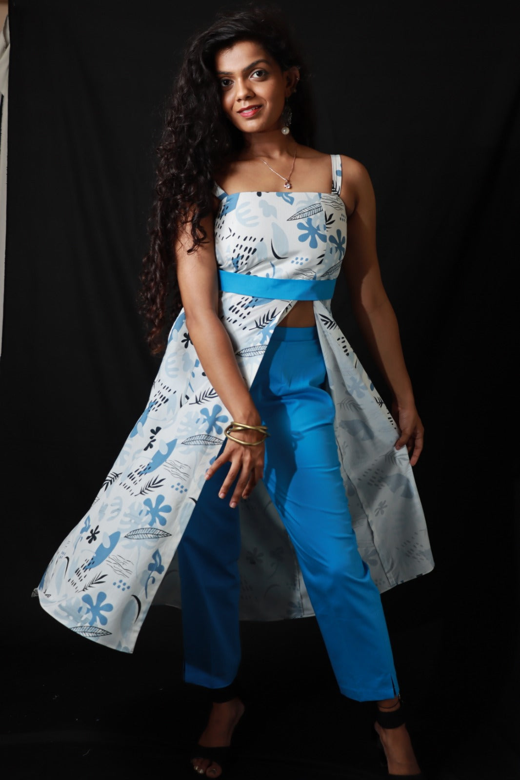 Two piece ensemble light colored, strappy top with sweetheart neckline and clinched waist featuring a floral and leaf pattern in blue casual wear