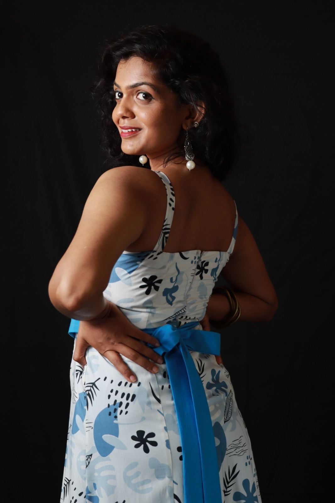 Two piece ensemble light colored, strappy top with sweetheart neckline and clinched waist featuring a floral and leaf pattern in blue casual wear