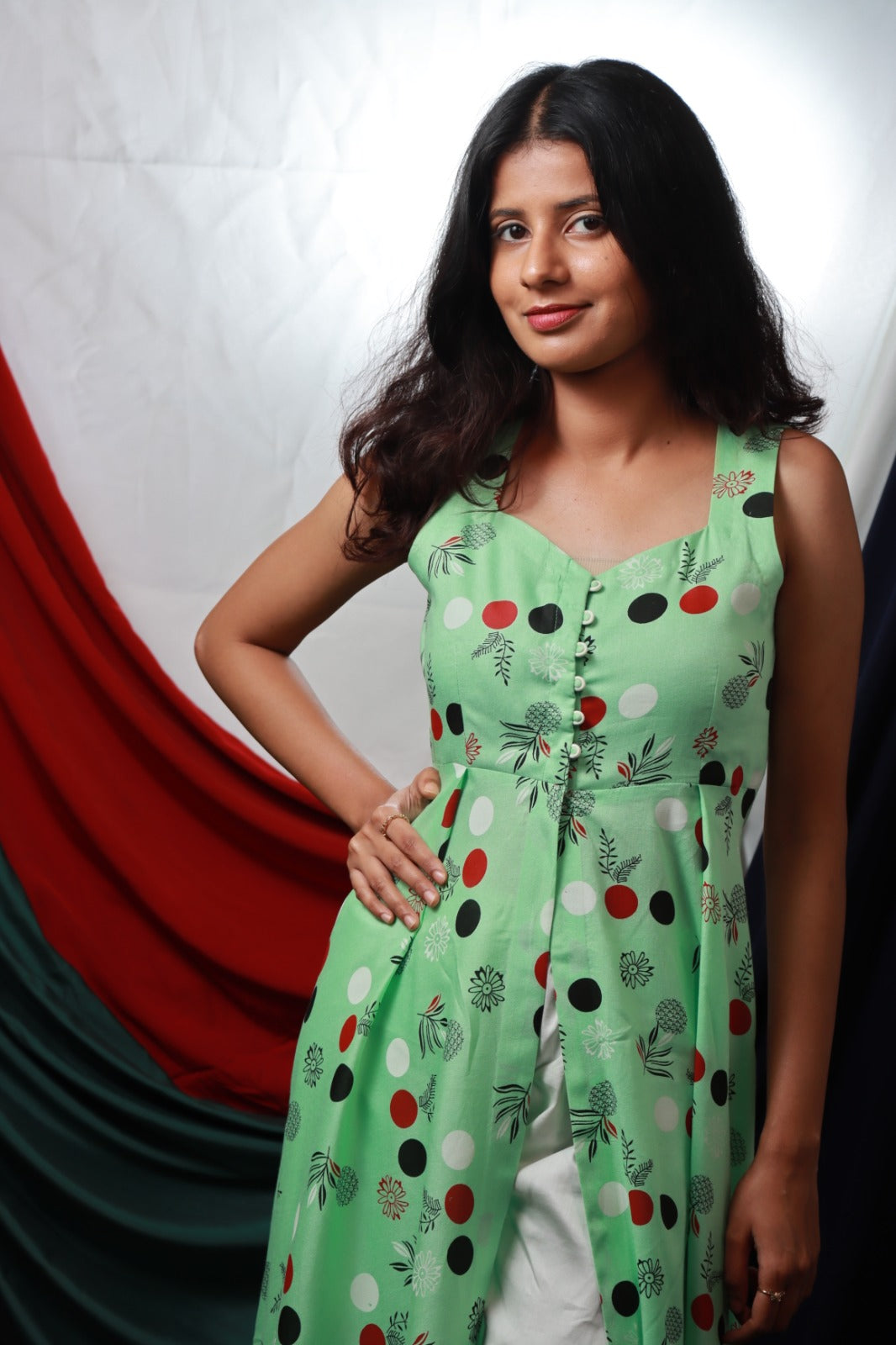 Light green sleeveless knee length kurthi with front slit and button detailing paired with wide leg white cream pant